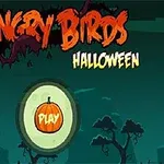 Logo s nápisom Angry Birds Halloween s tlačidlom Play vo forme tekvice na temnom pozadí s obrysmi stromov