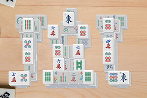 Hra s dlaždicami Mahjong uloženými v tvare siluety čísla 101 na drevenom povrchu