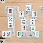 Hra s dlaždicami Mahjong uloženými v tvare siluety čísla 101 na drevenom povrchu