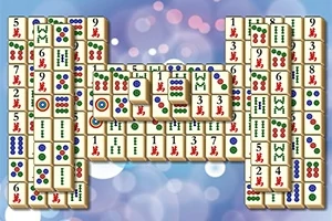 Stohy mahjong kameňov s rôznymi symbolmi na bokeh pozadí