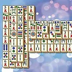 Stohy mahjong kameňov s rôznymi symbolmi na bokeh pozadí