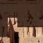 Starodávny chrám s veľkými sediacimi sochami a hieroglyfmi na kamenných stenách