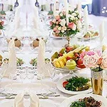 Elegantne prestretý stôl s kvetinovými aranžmánmi, ovocnými misami a elegantnými servítkami