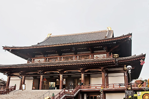 Tradičný japonský chrám s drevenou architektúrou a šikmou strechou na pozadí oblohy