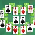 Kartové hracie pole s rozloženými kartami v tvare pokročilého usporiadania na zelenom pozadí