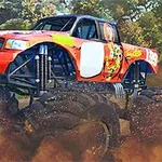 Obrovský oranžový monster truck prechádza cez prašný terén so stromami v pozadí