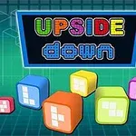 Farebný nápis UPSIDE down na tmavom pozadí s farebnými kockami v popredí na mriežkovanom pozadí
